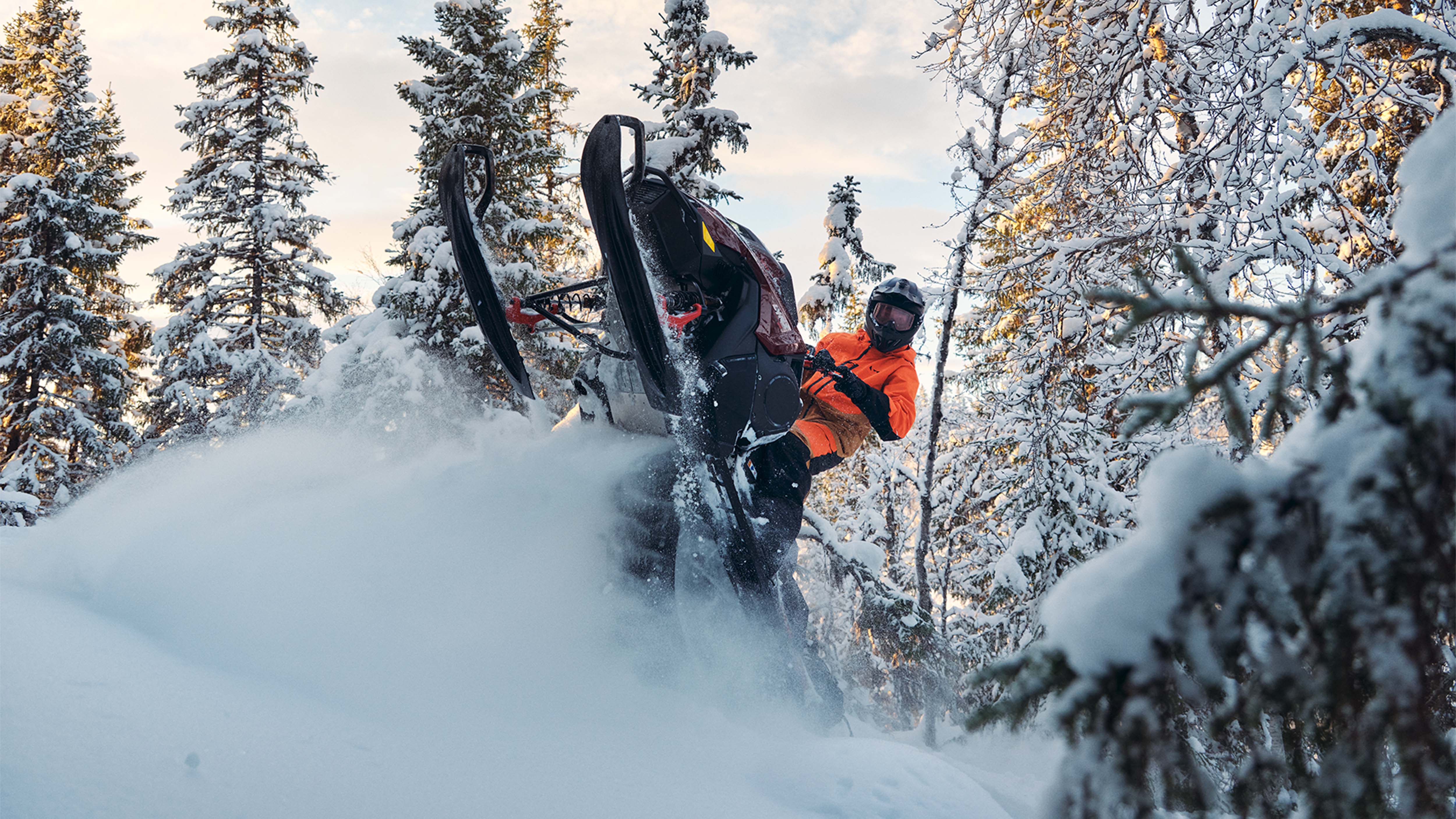 Lynx Shredder DS 2025 snowmobile wheelying in deep snow in forest