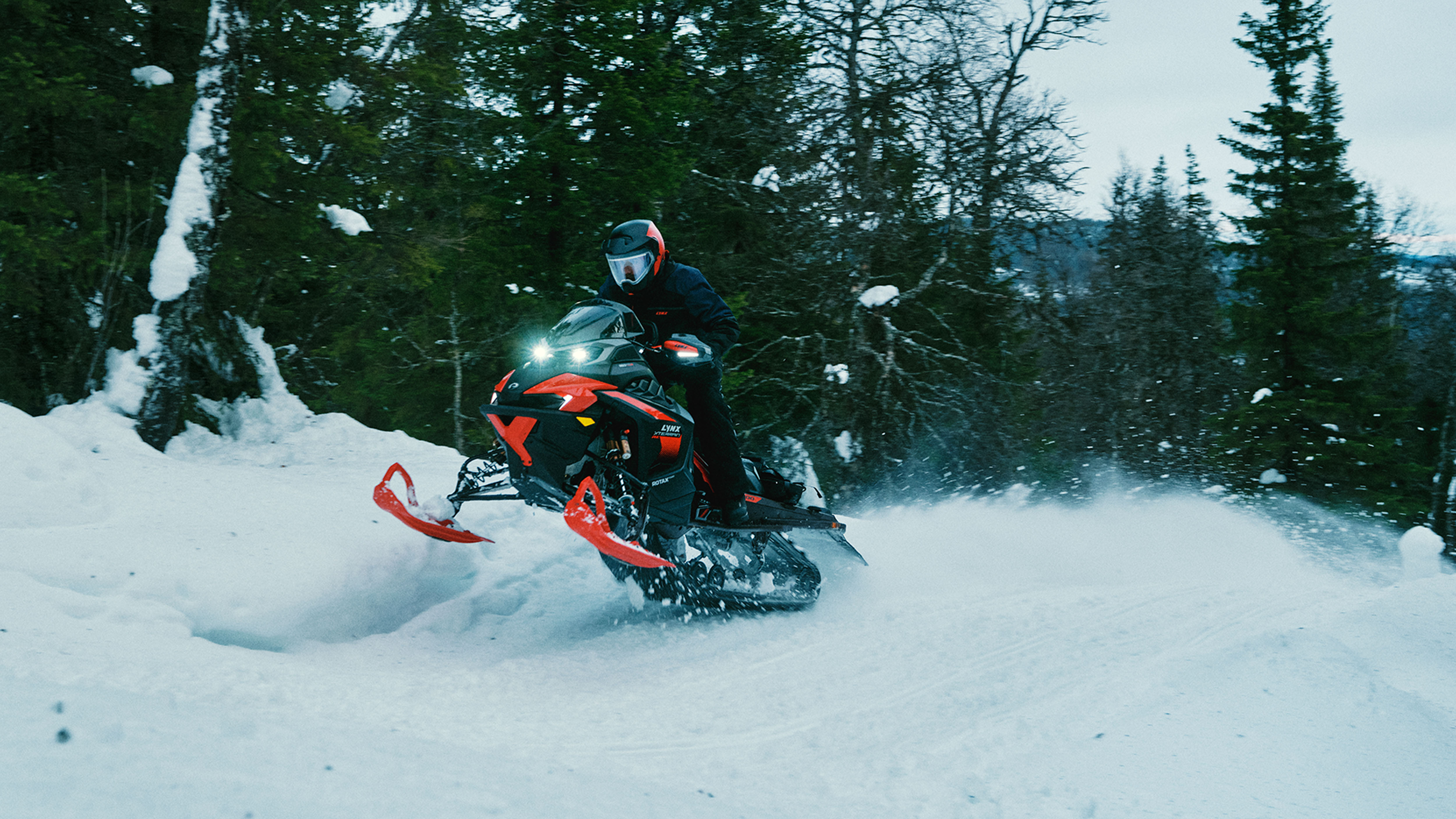 Lynx Xterrain RE 850 E-TEC Turbo R 2025 -moottorikelkka ajamassa vauhdikkaasti patikkoisella reitillä