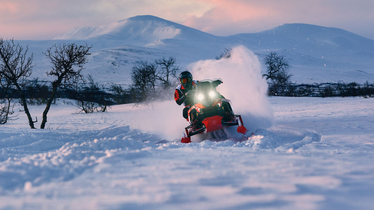Lynx Rave RE 2027 snowmobile cornering on bumpy trail