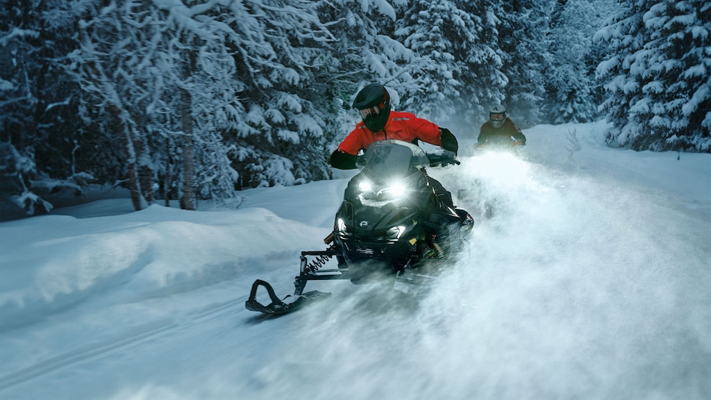 Lynx Brutal RE 2025 snøscooter som kjører opp en bratt skogsbakke