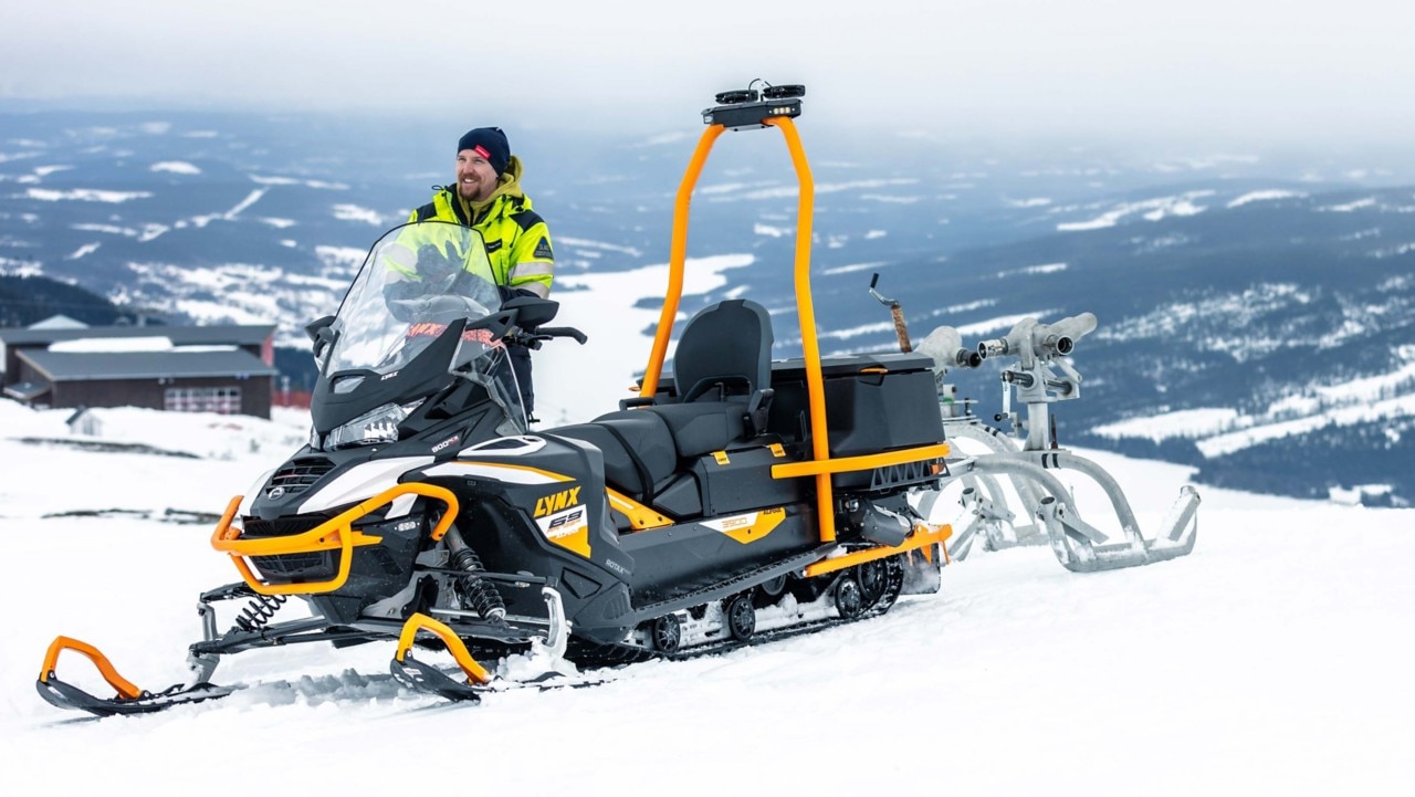 Lynx Brutal RE 2025 snøscooter som kjører opp en bratt skogsbakke