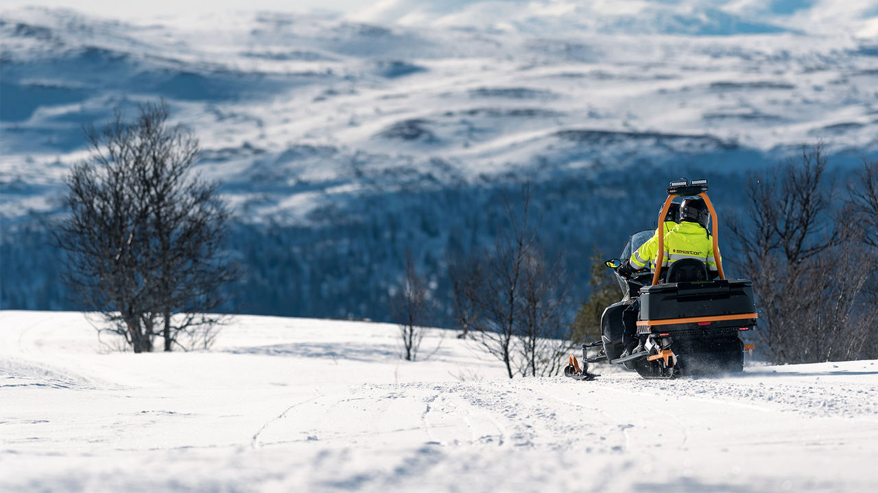 Lynx Brutal RE 2025 snøscooter som kjører opp en bratt skogsbakke